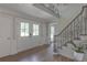Light-filled foyer with a staircase with rod iron railing, and wood floors creates a grand entrance at 1908 Musket Ct, Stone Mountain, GA 30087