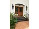 Elegant double front doors framed by sconces and decorative plants provide a warm welcome at 1908 Musket Ct, Stone Mountain, GA 30087