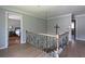 Upstairs landing with wood floors, decorative chandelier, and stairway with wood railing at 1908 Musket Ct, Stone Mountain, GA 30087