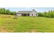 Expansive backyard featuring a vast green lawn, a fire pit, and mature trees lining the perimeter of the property at 2241 N 16 Hwy, Whitesburg, GA 30185