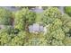 An aerial view of a house nestled among lush trees, featuring a deck with outdoor furniture and a charming driveway at 260 Waverly Hall Dr, Roswell, GA 30075