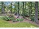 Backyard with an abundance of mature trees, shrubbery and lush ground cover at 260 Waverly Hall Dr, Roswell, GA 30075