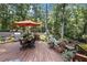 Outdoor deck with space for grilling and entertaining, surrounded by lush greenery and beautiful landscaping at 260 Waverly Hall Dr, Roswell, GA 30075