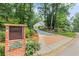 View of the brick mailbox and driveway leading to the house with mature trees and landscaping at 260 Waverly Hall Dr, Roswell, GA 30075