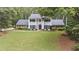 Stately two-story home with a manicured lawn, classic columns, and mature landscaping at 260 Waverly Hall Dr, Roswell, GA 30075