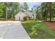 Side view showing a long driveway leading up to a brick two-car garage and white two-story home at 260 Waverly Hall Dr, Roswell, GA 30075