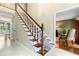 Bright foyer with marble floors, staircase with carpet runner, and a glimpse into the living room at 260 Waverly Hall Dr, Roswell, GA 30075