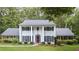 Traditional two-story home with white columns, black shutters, manicured lawn, and mature landscaping at 260 Waverly Hall Dr, Roswell, GA 30075