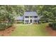 Expansive front lawn and mature trees frame this white two-story home with a brick accent and black shutters at 260 Waverly Hall Dr, Roswell, GA 30075