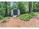 Outdoor storage shed surrounded by mulch, greenery, and a wooden fence at 260 Waverly Hall Dr, Roswell, GA 30075