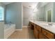 Bright bathroom featuring double vanity, soaking tub, and neutral tile flooring at 5018 Upper Elm St, Atlanta, GA 30349