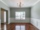 Bright dining room with hardwood floors, wainscoting, and a tray ceiling offers a sophisticated ambiance at 5018 Upper Elm St, Atlanta, GA 30349