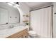 Bright bathroom featuring marble countertop, arch mirror, and decorative wooden shelves at 5315 Bentley Hall Dr, Alpharetta, GA 30005