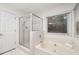 Bright bathroom with a separate shower and soaking tub, complemented by a large window and natural light at 5315 Bentley Hall Dr, Alpharetta, GA 30005
