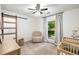 A well-lit bedroom showcases a barn door, a comfortable chair, and a crib at 5315 Bentley Hall Dr, Alpharetta, GA 30005