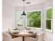 Cozy dining area with large windows offering backyard views, complemented by a modern light fixture at 5315 Bentley Hall Dr, Alpharetta, GA 30005