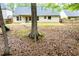 Large backyard featuring mature trees, a playset, a wooden fence, and a glimpse of the home's exterior, perfect for outdoor enjoyment at 1015 Buckeye Ln, Villa Rica, GA 30180