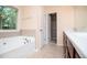 Well-lit bathroom with a large tub and a vanity with dark wood cabinets at 1015 Buckeye Ln, Villa Rica, GA 30180