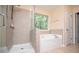 Bright bathroom featuring a separate shower and tub, plus a window view at 1015 Buckeye Ln, Villa Rica, GA 30180