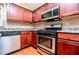 Close-up of the kitchen, showing stainless steel oven, microwave, dishwasher and cherry cabinets at 1015 Buckeye Ln, Villa Rica, GA 30180
