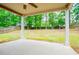 Covered patio with view of backyard, providing a serene outdoor living space with a ceiling fan and wood-framed pillars at 1015 Buckeye Ln, Villa Rica, GA 30180