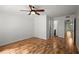 A bedroom with hardwood floors and a ceiling fan, showcasing a hallway leading to other rooms at 1384 N Crossing Ne Dr, Atlanta, GA 30329