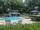 Community pool area with lounge chairs, umbrellas, and a charming clubhouse, perfect for relaxation and recreation at 1384 N Crossing Ne Dr, Atlanta, GA 30329