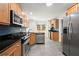 Modern kitchen with stainless steel appliances, wooden cabinets, and gray tile flooring at 1384 N Crossing Ne Dr, Atlanta, GA 30329