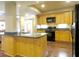 Cozy kitchen with wood cabinets, black appliances, granite countertops and hardwood floors at 154 Gold Leaf Trail Trl, Powder Springs, GA 30127