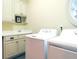 Bright laundry room with white washer and dryer, cabinets and countertop, and round window at 154 Gold Leaf Trail Trl, Powder Springs, GA 30127