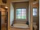 Clean bathroom showcasing a soaking tub, glass shower, and tiled accents, with window at 154 Gold Leaf Trail Trl, Powder Springs, GA 30127