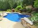Backyard oasis featuring a uniquely shaped pool and a tranquil waterfall at 154 Gold Leaf Trail Trl, Powder Springs, GA 30127