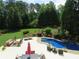 Aerial view of a stunning pool area, complete with outdoor seating and lush greenery at 154 Gold Leaf Trail Trl, Powder Springs, GA 30127