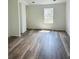 Spacious bedroom with wood-look flooring and a bright window view at 6662 Witherington Ct, Norcross, GA 30093