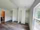 Bedroom with wood-look floors and closet space next to a sun-filled window at 6662 Witherington Ct, Norcross, GA 30093