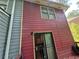 Red and grey two-story house with a deck, contrasting exterior, and a small yard at 964 Glynn Oaks Dr, Clarkston, GA 30021