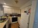 Well-lit kitchen featuring white cabinetry and modern appliances for a functional cooking space at 964 Glynn Oaks Dr, Clarkston, GA 30021