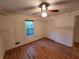 Bright bedroom with wood floors, window, closet, ceiling fan, and built-in shelving at 3054 Whisper Knob Rd, Marietta, GA 30062