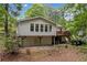 The home features a two-story layout with a visible basement and surrounding lush foliage at 307 Little Hickory Ln, Woodstock, GA 30189