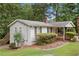 View of the side and back of the house with a small deck, landscaping, and backyard at 307 Little Hickory Ln, Woodstock, GA 30189