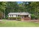 Charming single story home with a covered porch and lush, green landscaped front yard at 307 Little Hickory Ln, Woodstock, GA 30189