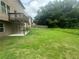Grassy backyard with small deck and patio with a tall wooden fence along the property at 443 Strawberry Walk, Loganville, GA 30052