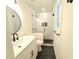 A stylish bathroom featuring a glass shower, black hardware, modern vanity, and sleek black marble floor at 705 Stewart Nw Cir, Marietta, GA 30064