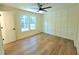 A bedroom with two windows, ceiling fan, white trim, and board and batten accent wall at 705 Stewart Nw Cir, Marietta, GA 30064