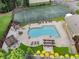 Aerial view featuring a pool, tennis court, and pergola in a lush community setting at 1274 Branch Dr, Tucker, GA 30084