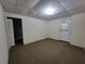 Finished basement area with neutral walls, carpet, a ceiling grid, and an access door to the exterior at 180 Preston Oaks Dr, Johns Creek, GA 30022
