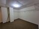 Finished basement area with neutral walls, carpet, closet organizers, and ceiling grid at 180 Preston Oaks Dr, Johns Creek, GA 30022