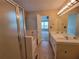 Bathroom with a double vanity, enclosed tub, and a view into the adjacent bedroom, allowing natural light at 180 Preston Oaks Dr, Johns Creek, GA 30022