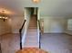 Open entryway featuring staircase with wood and white trim and neutral walls and carpet throughout at 180 Preston Oaks Dr, Johns Creek, GA 30022
