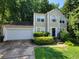 Two-story home featuring manicured landscaping, a two car garage, and traditional architectural design at 180 Preston Oaks Dr, Johns Creek, GA 30022